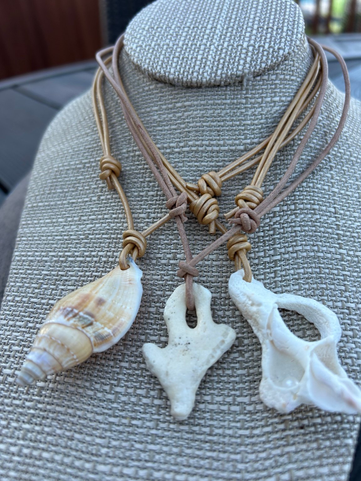 Three handmade Salty Dog Jewelry shell necklaces on leather cords